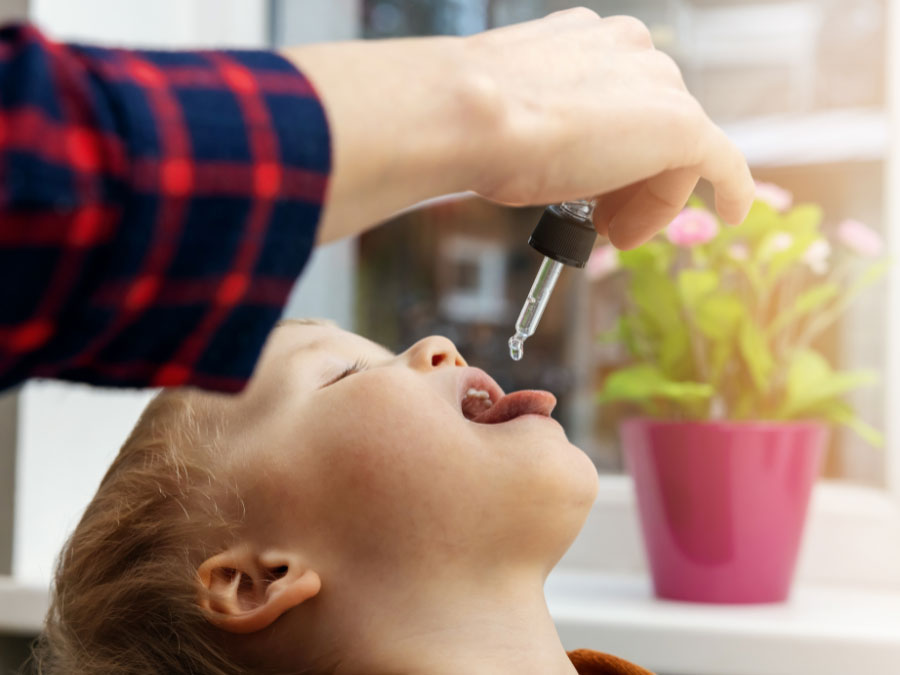 Persona che assume gocce sublinguali per l'immunoterapia delle allergie stagionali.
