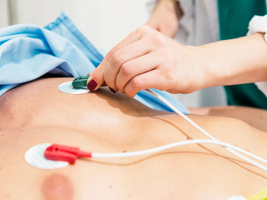 Medico che esegue un elettrocardiogramma su un paziente durante un controllo cardiologico.